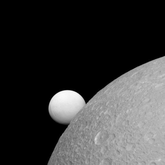 This image, taken with Cassini’s narrow-angle camera on September 8, shows Dione (near) and Enceladus (far). Although these moons are composed of nearly the same materials, Enceladus has a considerably higher reflectivity than Dione. This view looks toward the leading hemisphere of Enceladus. North on Enceladus is up and rotated 1 degree to the right. Image credit: NASA / JPL-Caltech / Space Science Institute.