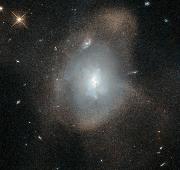 This Hubble image shows the elliptical galaxy LEDA 3087775. In this galaxy, some ribbons of dust notably obscure parts of the conglomerated galaxy’s central, bluish region; those dust lanes could be remnants of the spiral arms of the recently departed galaxies. Image credit: NASA / ESA / Hubble / Judy Schmidt, www.geckzilla.com.