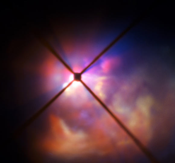 In this image from ESO’s Very Large Telescope (VLT) the red hypergiant star VY Canis Majoris is hidden behind an obscuring disc; the crosses are artifacts due to features in VLT’s SPHERE instrument. Image credit: ESO.