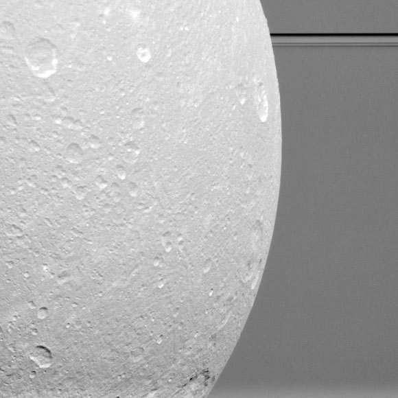 Dione in front of Saturn’s rings. This view, acquired by NASA’s Cassini spacecraft during a close flyby of the icy moon on August 17, is centered on terrain at 7 degrees south latitude, 122 degrees west longitude. Image credit: NASA / JPL-Caltech / Space Science Institute.