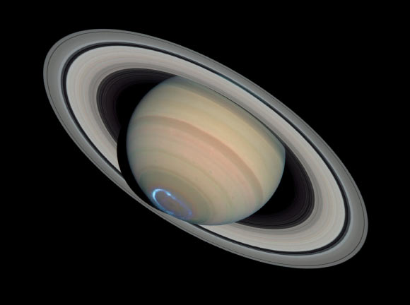 Photomontage of Saturn with a false-color image of UV aurora taken with Hubble’s Imaging Spectrograph on January 24, 2004, superimposed on an image of visible light taken with Hubble’s Advanced Camera for Surveys on March 22, 2004. Image credit: NASA / ESA / J. Clarke, Boston University / Z. Levay, STScI.