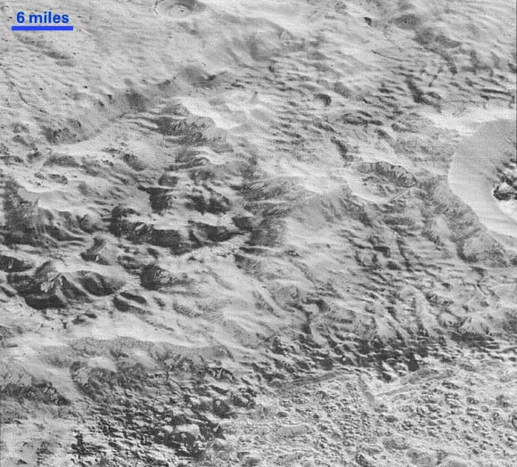 This image of Pluto’s surface shows how erosion and faulting has sculpted this portion of the dwarf planet’s icy crust into rugged badlands. The prominent 1.2-mile (2 km) high cliff at the top, running from left to upper right, is part of a great canyon system that stretches for hundreds of miles across Pluto’s northern hemisphere. At the bottom of this image, the terrain transforms into a fractured and finely broken up floor at the northwest margin of Sputnik Planum. The top of the image is to Pluto’s northwest. Image credit: NASA / Johns Hopkins University Applied Physics Laboratory / Southwest Research Institute.