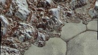 Mountainous shoreline of Sputnik Planum: in this enhanced color image, great blocks of Pluto’s water-ice crust appear jammed together in al-Idrisi mountains. Some mountain sides appear coated in dark material, while other sides are bright. Several sheer faces appear to show crustal layering, perhaps related to the layers seen in some of Pluto’s crater walls. The mountains end abruptly at the shoreline of Sputnik Planum, where exotic ices of the plain form a nearly level surface, broken only by the fine trace work of striking, cellular boundaries and the textured surface of the plain’s ices. Image credit: NASA / Johns Hopkins University Applied Physics Laboratory / Southwest Research Institute.