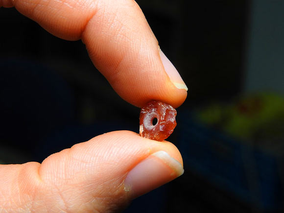 A 7,000-year-old bead made of carnelian. Image credit: Ronit Lupo / Israel Antiquities Authority.
