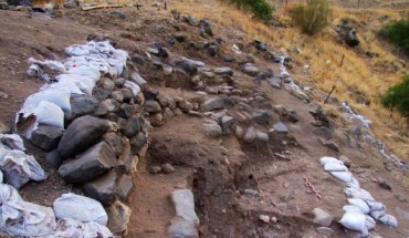Remains of a Natufian building at NEG II: the wall of this structure is 90 cm high and is the best preserved wall excavated thus far; it is composed of 5 courses of limestone and basalt stones; the wall tilts slightly away from the structure to the northwest and two large stones mark its base at the top of the Natufian occupation level; only the western side of the structure survived, yet the contour of the curve suggests a diameter of at least 5 m. Image credit: Grosman L. et al.
