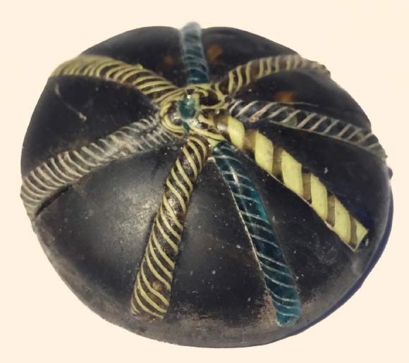 A glass counter decorated with twisted colorful strands was found at the site. Image credit: University of Sheffield. 
