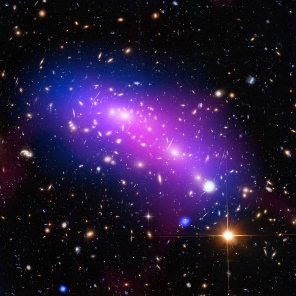 This image of the galaxy cluster MACS J0416 combines data from three telescopes - Hubble (showing the galaxies and stars), Chandra (diffuse emission in blue), and the Jansky Very Large Array (diffuse emission in pink). MACS J0416 acts as a powerful natural lens by bending and magnifying the light of far-more-distant objects behind it. Image credit: NASA / ESA / CXC / NRAO / AUI / NSF / STScI / G. Ogrean, Stanford University / J. Lotz, STScI / HFF Team.