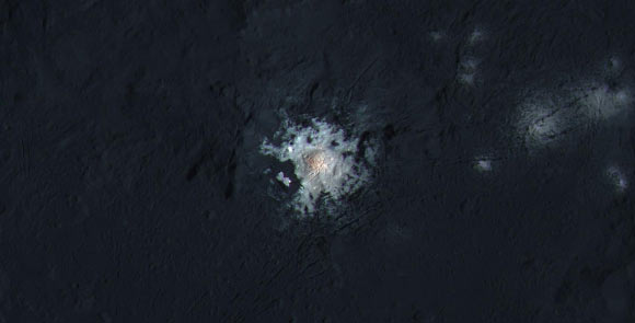 The bright spots near the center of Occator crater are shown in enhanced color in this view from NASA’s Dawn robotic spacecraft. Lower resolution color data have been overlaid onto a higher resolution view of the crater. The view was produced by combining the highest resolution images of Occator obtained in February 2016 with color images obtained in September 2015. The three images used to produce the color were taken using spectral filters centered at 438, 550 and 965 nanometers. Dawn’s close-up view reveals a dome in a smooth-walled pit in the bright center of the crater. Numerous linear features and fractures crisscross the top and flanks of this dome. Image credit: NASA / JPL-Caltech / UCLA / MPS / DLR / IDA / PSI / LPI.