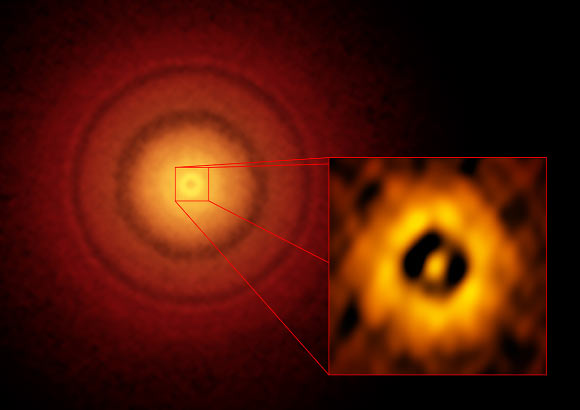 This ALMA image shows the planet-forming disc around TW Hydrae. The inset image zooms in on the gap nearest to the star, which is at the same distance as the Earth is from the Sun, suggesting an infant version of an Earth-like exoplanet could be emerging from the dust and gas. The additional concentric light and dark features represent other planet-forming regions farther out in the disc. Image credit: S. Andrews, Harvard-Smithsonian Center for Astrophysics / ALMA / ESO / NAOJ / NRAO.