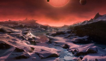 This artist’s impression shows an imagined view from the surface one of the three exoplanets orbiting the ultracool dwarf star TRAPPIST-1 38.8 light-years from Earth. These alien worlds have sizes and temperatures similar to those of Venus and Earth. In this view one of the inner planets is seen in transit across the disc of TRAPPIST-1. Image credit: M. Kornmesser / ESO.