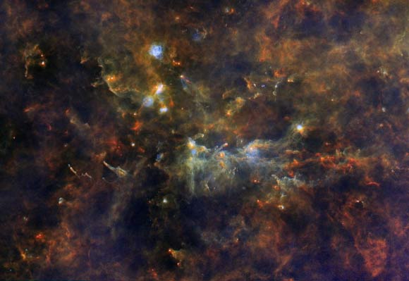This Herschel image shows Vulpecula OB1, a star-forming region about 8,000 light-years away in the constellation Vulpecula. It is a ‘stellar association’ in which a batch of truly giant OB stars (the largest stars that can form) is being born. The giant stars at the heart of Vulpecula OB1 are some of the biggest in our Galaxy. Containing dozens of times the mass of the Sun, they have short lives, astronomically speaking, because they burn their fuel so quickly. At an estimated age of 2 million years, they are already well through their lifespans. When their fuel runs out, they will collapse and explode as supernovae. The shock this will send through the surrounding cloud will trigger the birth of even more stars, and the cycle will begin again. Image credit: ESA / Herschel / PACS / SPIRE / Hi-GAL Project / G. Li Causi, IAPS / INAF.