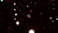 Canarias Einstein ring: the central lensing galaxy is shown in red and the blue Einstein ring is visible all around it. Image credit: M. Bettinelli et al / DECam / CTIO.