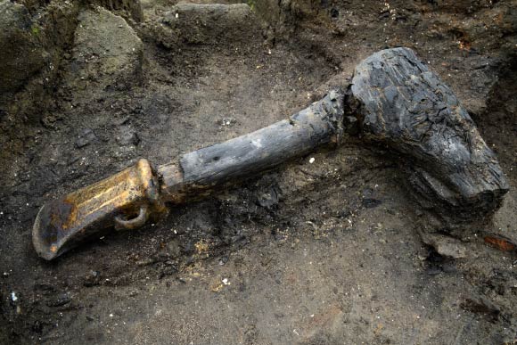 Bronze socketed axe with a wooden haft, or handle, which shows signs of charring. Image credit: Dave Webb / Cambridge Archaeological Unit.