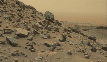 This view from Curiosity’s Mast Camera shows a sloping hillside within the ‘Murray Buttes’ region on lower Mount Sharp. The rim of Gale Crater, where the rover has been active since landing in 2012, is visible in the distance, through the dusty haze. The image was taken on September 8, 2016, during the 1454th Martian day, or sol, of Curiosity’s work on Mars. Image credit: NASA / JPL-Caltech / MSSS.