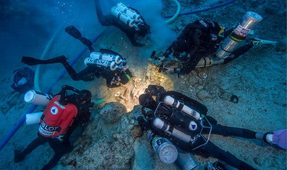 Archaeologists Brendan Foley, Theotokis Theodoulou and Alex Tourtas excavate the Antikythera shipwreck skeletal remains, assisted by Nikolas Giannoulakis and Gemma Smith. Image credit: Brett Seymour / EUA / WHOI / ARGO.