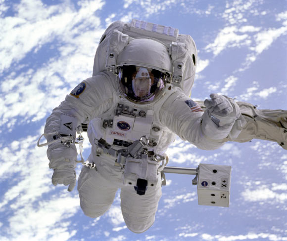 The pale blue Earth serves as a backdrop for astronaut Michael Gernhardt, who is attached to the Shuttle Endeavour’s robot arm during a spacewalk on the STS-69 mission in 1995. Unlike earlier spacewalking astronauts, Gernhardt was able to use an electronic cuff checklist, a prototype developed for the assembly of the International Space Station. Image credit: NASA.