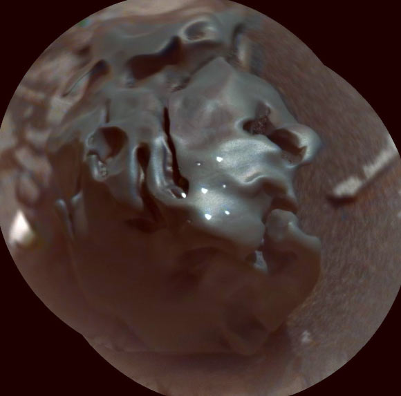 The smooth-surfaced object in this composite, colorized view from Curiosity’s ChemCam instrument shows a grid of shiny dots where ChemCam had fired laser pulses used for determining the chemical elements in the target’s composition. The analysis confirmed that this object is an iron-nickel meteorite. Image credit: NASA / JPL-Caltech / LANL / CNES / IRAP / LPG Nantes / CNRS / IAS / MSSS.