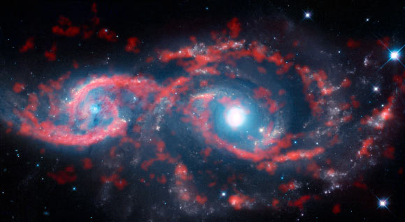 This image, a composite of data from ALMA and the NASA/ESA Hubble Space Telescope, shows a very rare cosmic sight: a pair of interacting galaxies that have taken on an ocular structure. Image credit: ALMA / ESO / NAOJ / NRAO / M. Kaufman.