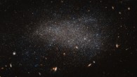This Hubble image shows the dwarf irregular galaxy NGC 4789A. The image also reveals numerous other galaxies, far more distant, that appear as fuzzy shapes spread across the image. The colors in this image have been deliberately exaggerated to emphasize the mix of blue and red stars. The blue stars are bright, hot and massive stars that have formed relatively recently, whereas the red stars are much older. The presence of both tells us that stars have been forming in this galaxy throughout its history. Image credit: NASA / ESA / Hubble / Judy Schmidt, www.geckzilla.com.