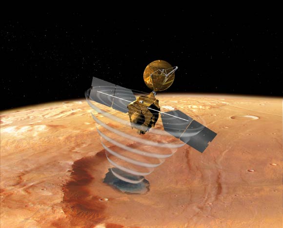 This image is an artist’s concept of a view looking down on NASA’s Mars Reconnaissance Orbiter. The spacecraft is pictured using its SHARAD instrument to ‘look’ under the surface of Mars. Image credit: NASA.