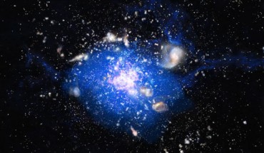 B.H.C. Emonts et al found that the Spiderweb, a massive galaxy in the center of a distant protocluster, is forming from a large reservoir of molecular gas. In this artist’s conception of the protocluster, the protogalaxies are shown in white and pink, and the blue indicates the location of the carbon monoxide gas. Image credit: M. Kornmesser / ESO.