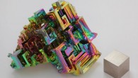 Artificially grown bismuth crystal illustrating the stairstep structure, with a 1 cm3 cube of bismuth metal. Image credit: Heinrich Pniok / CC BY-NC-ND 3.0.