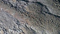 In this extended color image of Pluto taken by NASA’s New Horizons spacecraft, rounded and bizarrely textured mountains, named the Tartarus Dorsa, rise up along Pluto’s day-night terminator and show intricate but puzzling patterns of blue-gray ridges and reddish material in between. This view, roughly 330 miles (530 km) across, combines blue, red and infrared images taken by New Horizons’ Ralph/Multispectral Visual Imaging Camera on July 14, 2015. Image credit: NASA / Johns Hopkins University Applied Physics Laboratory / Southwest Research Institute.