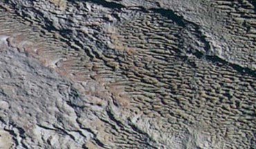 In this extended color image of Pluto taken by NASA’s New Horizons spacecraft, rounded and bizarrely textured mountains, named the Tartarus Dorsa, rise up along Pluto’s day-night terminator and show intricate but puzzling patterns of blue-gray ridges and reddish material in between. This view, roughly 330 miles (530 km) across, combines blue, red and infrared images taken by New Horizons’ Ralph/Multispectral Visual Imaging Camera on July 14, 2015. Image credit: NASA / Johns Hopkins University Applied Physics Laboratory / Southwest Research Institute.