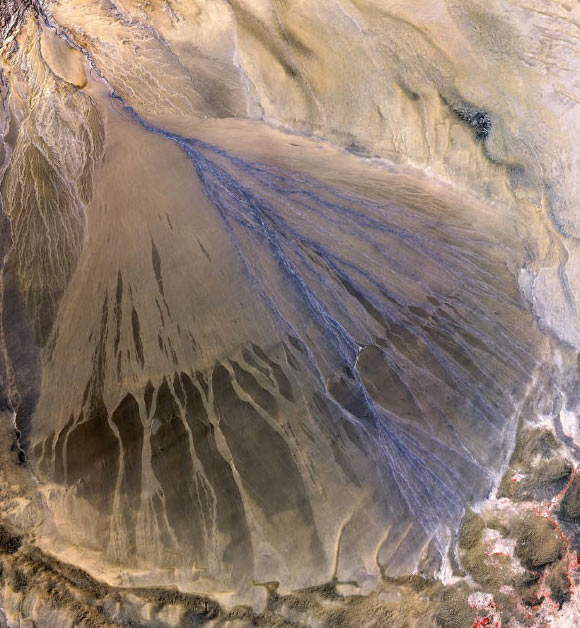 A vast alluvial fan in the XinJiang province of China. The right side is the active part of the fan, and appears blue from water currently flowing in the many small streams. The image was acquired on May 2, 2002. Image credit: NASA / GSFC / METI / ERSDAC / JAROS / US-Japan ASTER Science Team.