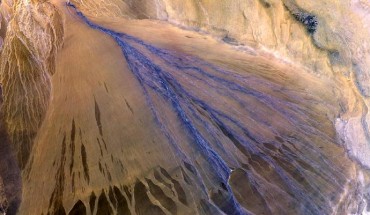 A vast alluvial fan in the XinJiang province of China. The right side is the active part of the fan, and appears blue from water currently flowing in the many small streams. The image was acquired on May 2, 2002. Image credit: NASA / GSFC / METI / ERSDAC / JAROS / US-Japan ASTER Science Team.