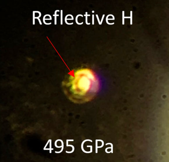 Photo of metallic hydrogen at a pressure of 495 GPa; the sample is non-transmitting and is observed in reflected light; the central region is clearly more reflective than the surrounding metallic rhenium gasket; the sample dimensions are approximately 8-10 microns with thickness 1.2 microns. Image credit: Ranga P. Dias & Isaac F. Silvera, doi: 10.1126/science.aal1579.