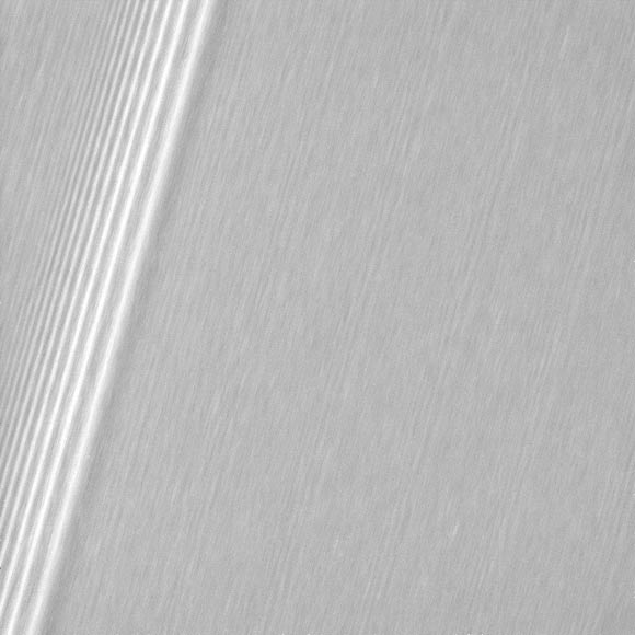 This image shows a region in Saturn’s A ring. The level of detail is twice as high as this part of the rings has ever been seen before. The view shows a section of the A ring known to researchers for hosting belts of propellers -- bright, narrow, propeller-shaped disturbances in the ring produced by the gravity of unseen embedded moonlets. Several small propellers are visible in this view. These are on the order of 10 times smaller than the large, bright propellers whose orbits scientists have routinely tracked. The prominent feature at left is a density wave created by the ring’s gravitational interaction with Saturn’s moon Prometheus (the 12:11 resonance). The image was taken in visible light with Cassini’s wide-angle camera on December 18, 2016. The view was obtained at a distance of approximately 33,000 miles (54,000 km) from the rings and looks toward the unilluminated side of the rings. Image credit: NASA / JPL-Caltech / Space Science Institute.