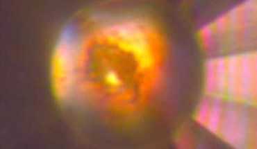 Microphotograph of the diamond anvil cell high-pressure cavity in reflected and transmitted light at 140 GPa after laser heating to > 1,500 degrees Kelvin. The sample, which consists of mixture of tI19 Na and Na2He, is in contact with He medium that is seen as a transparent area near the edge of the gasket. Image credit: Xiao Dong et al, doi: 10.1038/nchem.2716.