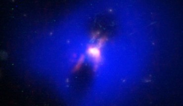 Composite image showing how powerful radio jets from the supermassive black hole at the center of a galaxy in the Phoenix Cluster inflated huge ‘bubbles’ in the hot, ionized gas surrounding the galaxy (the cavities inside the blue region imaged by NASA's Chandra X-ray observatory). Hugging the outside of these bubbles, ALMA discovered an unexpected trove of cold gas, the fuel for star formation (red). The background image is from the NASA/ESA Hubble Space Telescope. Image credit: ALMA / ESO / NAOJ / NRAO / NASA / ESA / Hubble / CXC / MIT / H. Russell et al / M. McDonald et al / B. Saxton.