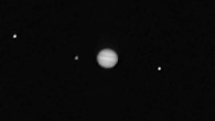 This composite image showing Jupiter (center) and three of its moons -- Callisto (left), Io, and Ganymede -- was taken by OSIRIS-REx’s PolyCam instrument. Image credit: NASA / Goddard / University of Arizona.