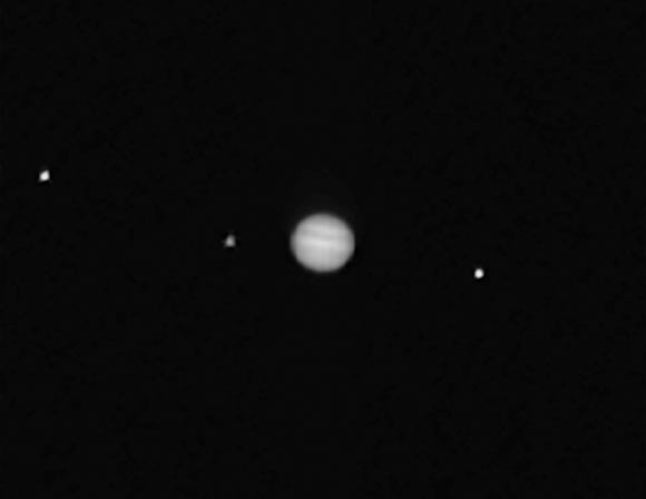 This composite image showing Jupiter (center) and three of its moons -- Callisto (left), Io, and Ganymede -- was taken by OSIRIS-REx’s PolyCam instrument. Image credit: NASA / Goddard / University of Arizona.