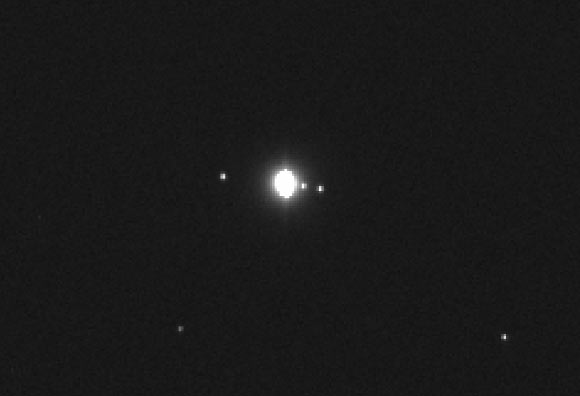 This magnified, cropped image showing Jupiter and three of its moons was taken by OSIRIS-REx’s MapCam instrument. The image shows Jupiter in the center, the moon Callisto to the left and the moons Io and Europa to the right. Ganymede, Jupiter’s fourth Galilean moon, is also present in the image, but is not visible as it is crossing in front of the planet. Image credit: NASA / Goddard / University of Arizona.