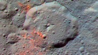 This enhanced color composite image, made with data from NASA’s Dawn spacecraft, shows the area around Ernutet crater, which is about 32 miles (52 km) in diameter and is located in the northern hemisphere. The bright red portions appear redder with respect to the rest of Ceres. In the new study, planetary researchers found that these red areas around Ernutet are associated with evidence of organic material. Images taken using blue (440 nm), green (750 nm) and infrared (960 nm) spectral filters were combined to create the view. Image credit: NASA / JPL-Caltech / UCLA / MPS / DLR / IDA.