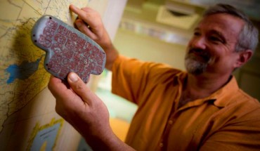 Pro.f Braswell holds a replica of the Maya jade pendant. Image credit: Erik Jepsen, University of California, San Diego Publications.