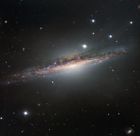 This VLT image shows the spiral galaxy NGC 1055. This large galaxy appears to lack the whirling arms characteristic of a spiral, as it is seen edge-on; however, it displays odd twists in its structure that were probably caused by an interaction with a large neighboring galaxy, Messier 77. The VLT observed NGC 1055 with the FOcal Reducer and low dispersion Spectrograph 2 (FORS2) instrument using visible-light filters. Image credit: ESO.