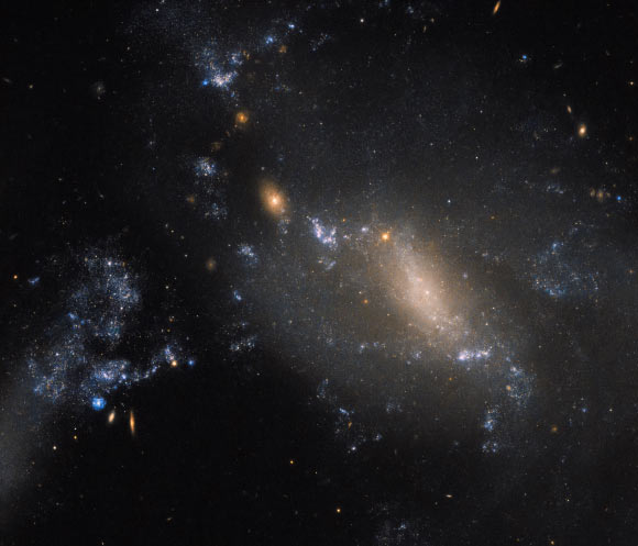 This Hubble image captures an ongoing cosmic collision between two galaxies: NGC 3447A and NGC 3447B. Image credit: NASA / ESA / Hubble.