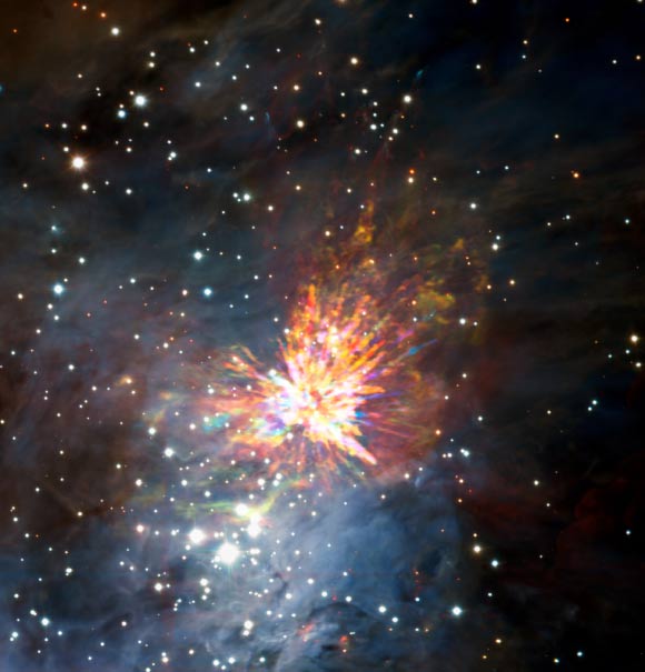 Stellar explosions are often associated with supernovae, the powerful and catastrophic deaths of stars. But new ALMA observations of the Orion Nebula complex provide insights into explosions at the other end of the stellar life cycle -- star birth. The colors in the ALMA data represent the relative Doppler shifting of the millimeter-wavelength light emitted by carbon monoxide gas. The blue color represents gas approaching at the highest speeds; the red color is from gas moving toward us more slowly. The background image includes optical and near-infrared imaging from both the Gemini South and ESO’s Very Large Telescope. The famous Trapezium Cluster of hot young stars appears towards the bottom of this image. Image credit: ALMA / ESO / NAOJ / NRAO / J. Bally / H. Drass et al.
