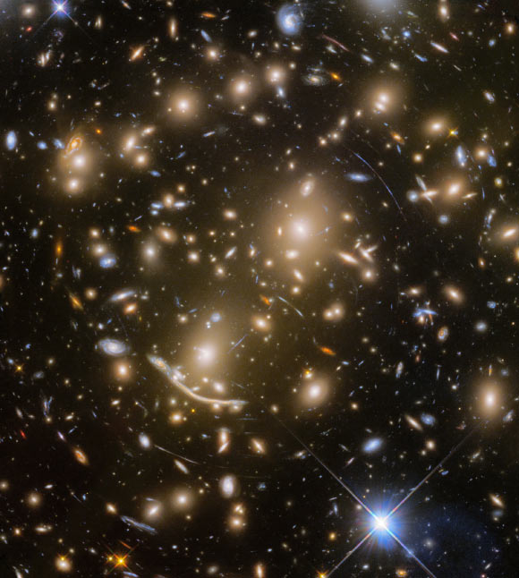 With the final observation of the distant galaxy cluster Abell 370 -- approximately 6 billion light-years away -- the Frontier Fields program came to an end. Abell 370 is one of the very first galaxy clusters in which astronomers observed the phenomenon of gravitational lensing, the warping of spacetime by the cluster’s gravitational field that distorts the light from galaxies lying far behind it. This manifests as arcs and streaks in the picture, which are the stretched images of background galaxies. Image credit: NASA / ESA / Hubble / HST Frontier Fields.