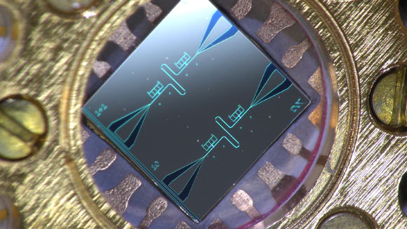 Photo of the centimeter-sized silicon chip, which has two parallel superconducting oscillators and the quantum-circuit refrigerators connected to them. Image credit: Kuan Yen Tan / Aalto University.