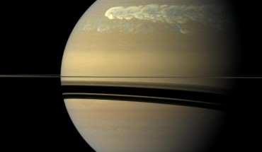 The huge storm churning through the atmosphere in Saturn’s northern hemisphere overtakes itself as it encircles the planet in this true-color view from NASA’s Cassini spacecraft. This picture, captured on Feb. 25, 2011, was taken about 12 weeks after the storm began, and the clouds by this time had formed a tail that wrapped around the planet. Some of the clouds moved south and got caught up in a current that flows to the east (to the right) relative to the storm head. This tail, which appears as slightly blue clouds south and west (left) of the storm head, can be seen encountering the storm head in this view. This storm is the largest, most intense storm observed on Saturn by NASA’s Voyager or Cassini spacecraft. It is still active today. As scientists have tracked this storm over several months, they have found it covers 500 times the area of the largest of the southern hemisphere storms observed earlier in the Cassini mission. The shadow cast by Saturn’s rings has a strong seasonal effect, and it is possible that the switch to powerful storms now being located in the northern hemisphere is related to the change of seasons after the planet’s August 2009 equinox. Image credit: NASA / JPL-Caltech / Space Science Institute.