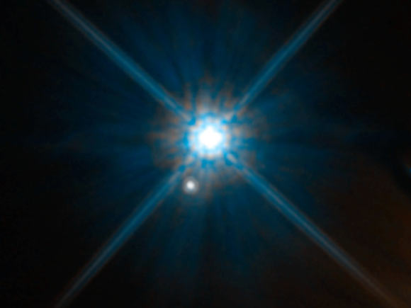 The white dwarf star Stein 2051B (center) is 17 light-years away and the background star is 5,000 light-years away. Image credit: NASA / ESA / K. Sahu, STScI.