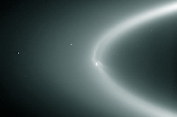 NASA image of Enceladus within the E ring in orbit around Saturn, where it is possible that the methanol detection could originate further out in the E ring. Enceladus is the dark spot inside the bright flare, right near the center of the E ring. Image credit: NASA / ESA / JPL-Caltech / Space Science Institute / CICLOPS.