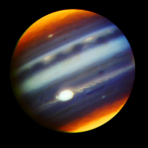 This composite, false-color infrared image of Jupiter reveals haze particles over a range of altitudes, as seen in reflected sunlight. It was taken using the Gemini North telescope’s Near-InfraRed Imager (NIRI) on May 18, 2017. The multiple filters corresponding to each color used in the image cover wavelengths between 1.69 microns and 2.275 microns. Jupiter’s Great Red Spot (GRS) appears as the brightest (white) region at these wavelengths, which are primarily sensitive to high-altitude clouds and hazes near and above the top of Jupiter's convective region. The GRS is one of the highest-altitude features in Jupiter’s atmosphere. Narrow spiral streaks that appear to lead into it or out of it from surrounding regions probably represent atmospheric features being stretched by the intense winds within the GRS, such as the hook-like structure on its western edge (left side). Some are being swept off its eastern edge (right side) and into an extensive wave-like flow pattern, and there is even a trace of flow from its northern edge. Other features near the GRS include the dark block and dark oval to the south and the north of the eastern flow pattern, respectively, indicating a lower density of cloud and haze particles in those locations. Both are long-lived cyclonic circulations, rotating clockwise -- in the opposite direction as the counterclockwise rotation of the GRS. A prominent wave pattern is evident north of the equator, along with two bright ovals, which are anticyclones that appeared in January 2017. Both the wave pattern and the ovals may be associated with an impressive upsurge in stormy activity that has been observed in these latitudes this year. Another bright anticyclonic oval is seen further north. High hazes are evident over both polar regions with much spatial structure not previously been seen quite so clearly in ground-based images. Image credit: Gemini Observatory / AURA / NASA / JPL-Caltech.