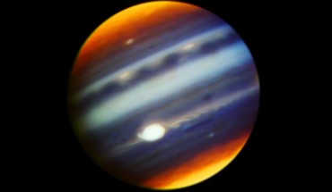 This composite, false-color infrared image of Jupiter reveals haze particles over a range of altitudes, as seen in reflected sunlight. It was taken using the Gemini North telescope’s Near-InfraRed Imager (NIRI) on May 18, 2017. The multiple filters corresponding to each color used in the image cover wavelengths between 1.69 microns and 2.275 microns. Jupiter’s Great Red Spot (GRS) appears as the brightest (white) region at these wavelengths, which are primarily sensitive to high-altitude clouds and hazes near and above the top of Jupiter's convective region. The GRS is one of the highest-altitude features in Jupiter’s atmosphere. Narrow spiral streaks that appear to lead into it or out of it from surrounding regions probably represent atmospheric features being stretched by the intense winds within the GRS, such as the hook-like structure on its western edge (left side). Some are being swept off its eastern edge (right side) and into an extensive wave-like flow pattern, and there is even a trace of flow from its northern edge. Other features near the GRS include the dark block and dark oval to the south and the north of the eastern flow pattern, respectively, indicating a lower density of cloud and haze particles in those locations. Both are long-lived cyclonic circulations, rotating clockwise -- in the opposite direction as the counterclockwise rotation of the GRS. A prominent wave pattern is evident north of the equator, along with two bright ovals, which are anticyclones that appeared in January 2017. Both the wave pattern and the ovals may be associated with an impressive upsurge in stormy activity that has been observed in these latitudes this year. Another bright anticyclonic oval is seen further north. High hazes are evident over both polar regions with much spatial structure not previously been seen quite so clearly in ground-based images. Image credit: Gemini Observatory / AURA / NASA / JPL-Caltech.