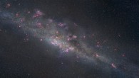 This artist’s illustration portrays what the gravitationally lensed galaxy SGAS 1110 might look like up close. A sea of young, blue stars is streaked with dark dust lanes and studded with bright pink patches that mark sites of star formation. SGAS 1110 is one of more than 70 studied as part of the Sloan Giant Arcs Survey, an imaging survey that searched 240 galaxy clusters to find new examples of gravitational lensing. Image credit: NASA / ESA / Z. Levay, STScI.